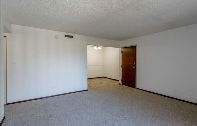 a bedroom with white walls and a carpeted floor