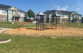 a playground in a park with houses in the background