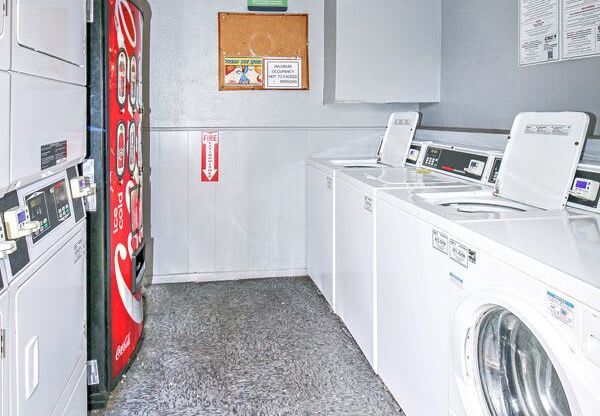 a laundry room with washing machines and a coke machine