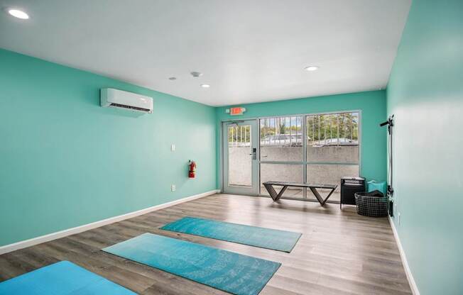 A yoga studio with blue mats on the floor.