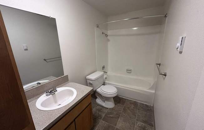 A bathroom with a toilet, sink, and bathtub.