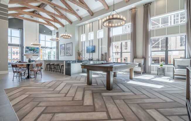 a large living room with a pool table and large windows