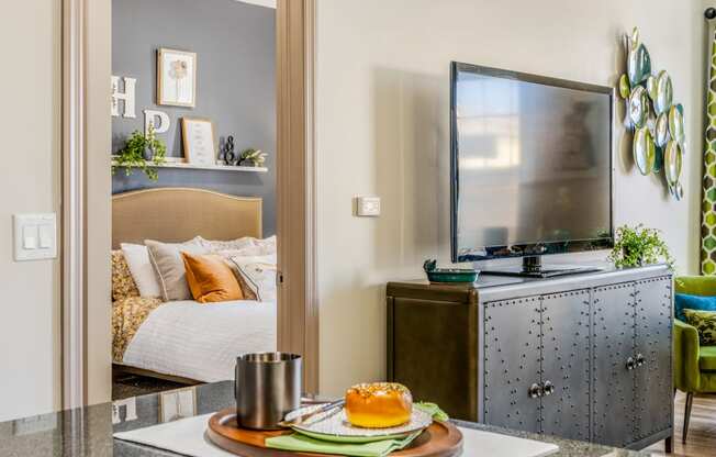 a bedroom with a tv and a table with a plate of food