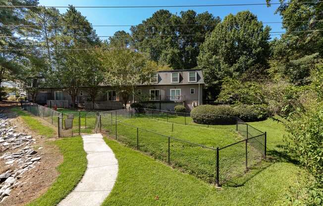 a house with a fenced in yard and a sidewalk