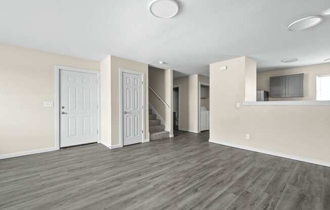 an empty living room with white walls and wood flooring at Diamond Ridge Townhomes, Oklahoma