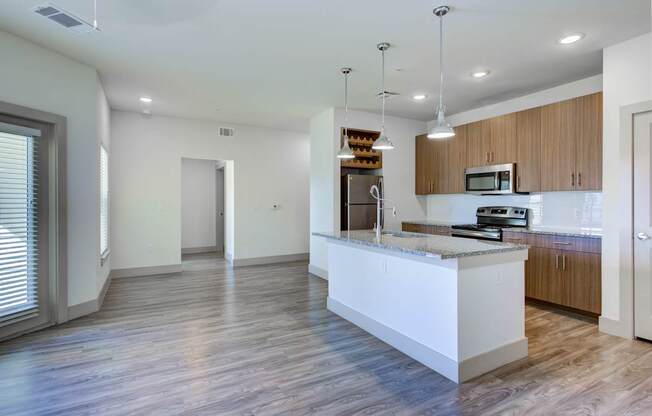A modern kitchen with a white island and wooden cabinets.