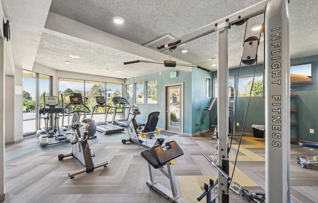 A gym with a variety of equipment including treadmills, exercise bikes, and weight machines.