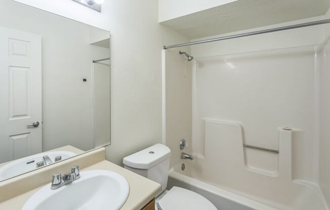 a bathroom with a sink toilet and shower and a mirror