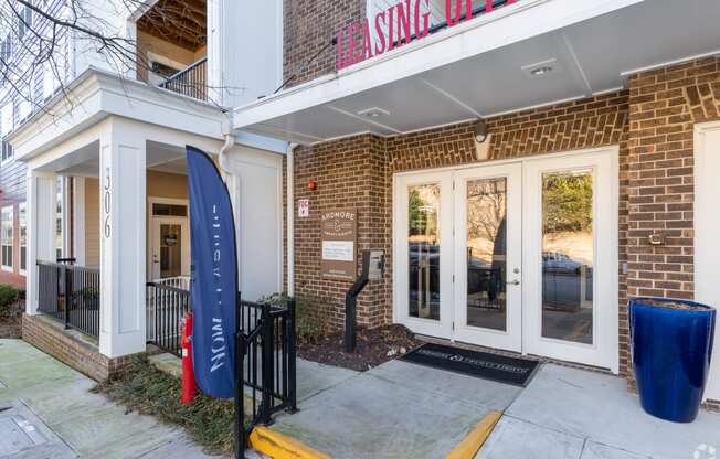 a brick building with glass doors and a sign on the side of it