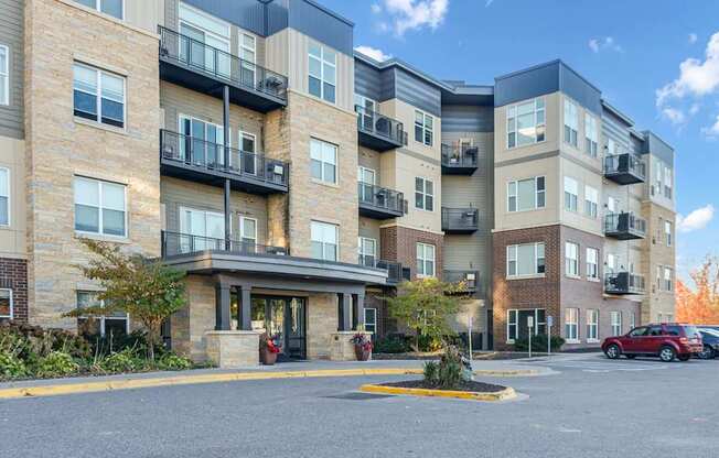 A large apartment complex with a parking lot in front.