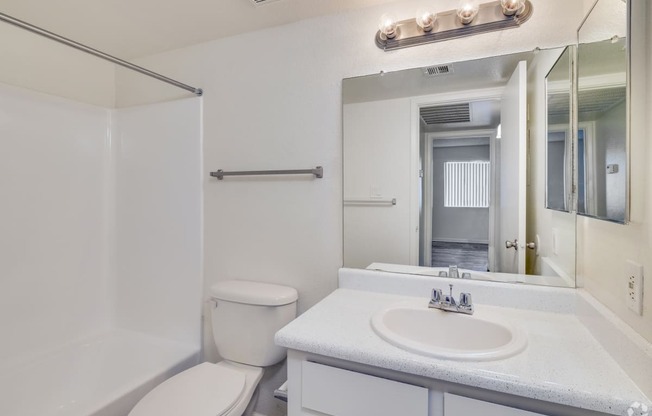 a bathroom with a sink toilet and a mirror