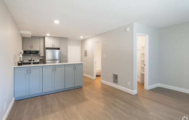 a kitchen and living room with blue cabinets and a wood floor