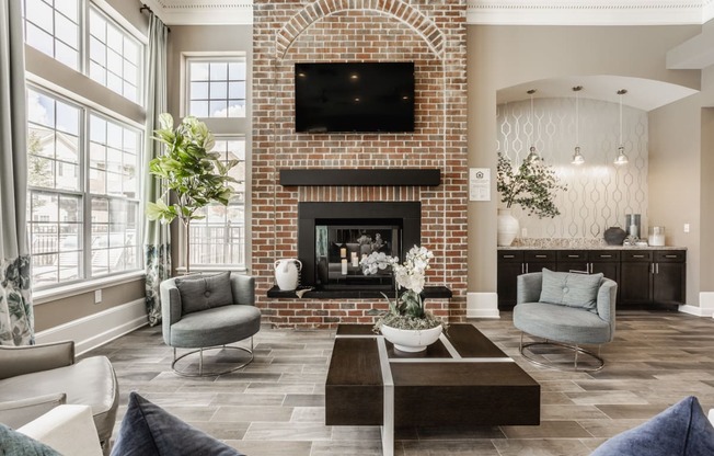 a living room with couches and a coffee table and a brick fireplace