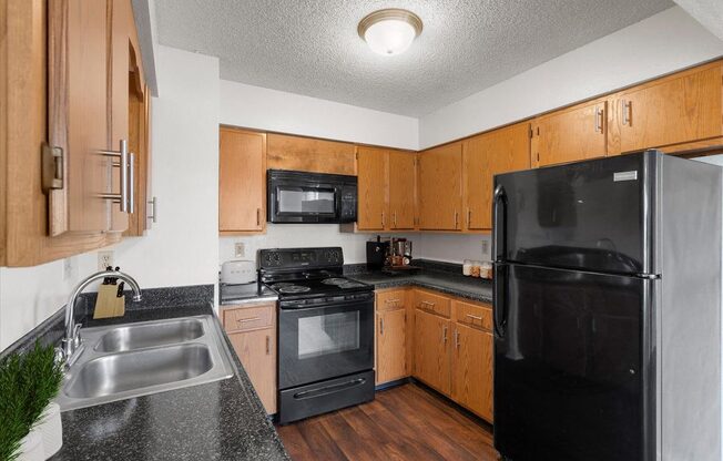 a kitchen with black appliances and wooden cabinets