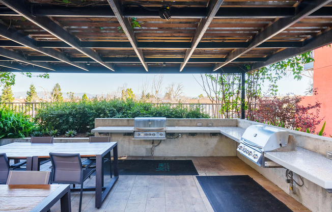 A patio with a table and chairs under a roof.