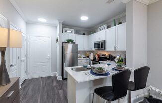 an open kitchen and dining area with stainless steel appliances and white cabinets