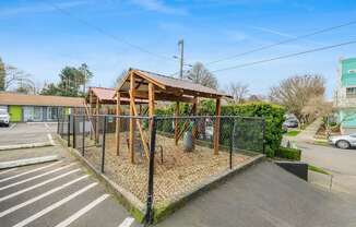 A playground with a wooden structure and a black fence.