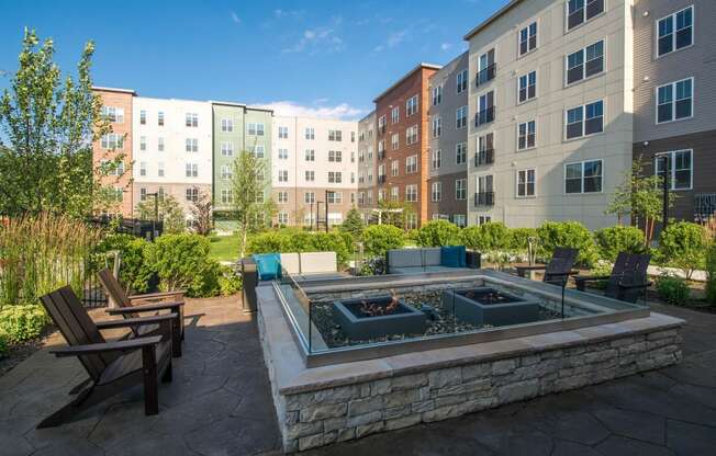 an outdoor patio with a fire pit and an apartment building