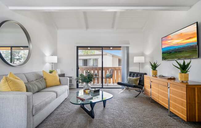 a living room with a gray couch and a glass coffee table
