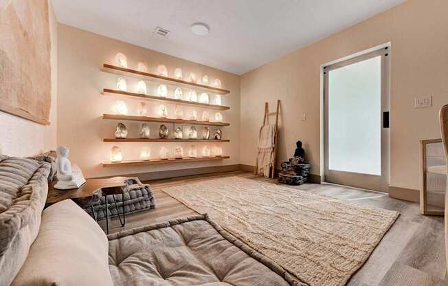 A living room with a couch, a rug, and a wall with lights on it.