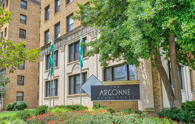 an apartment building with a sign in front of a garden