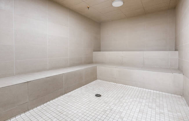 a white tiled bathroom with a shower and a tub