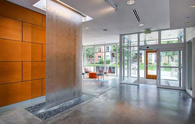 A hallway with a brown wall and a metal pillar.