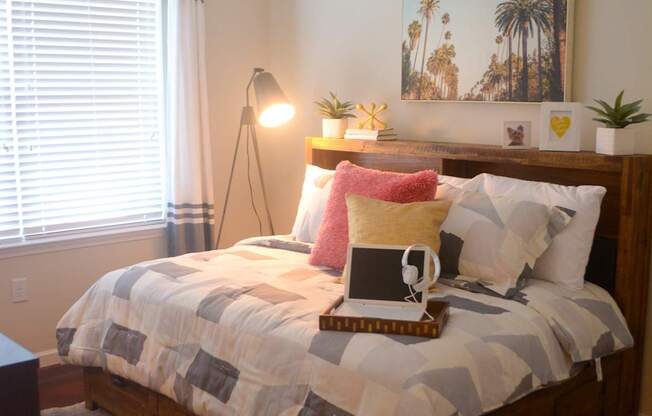A bed with a quilt and a lamp on it.
