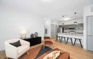 a living room with a couch and a chair and a kitchen