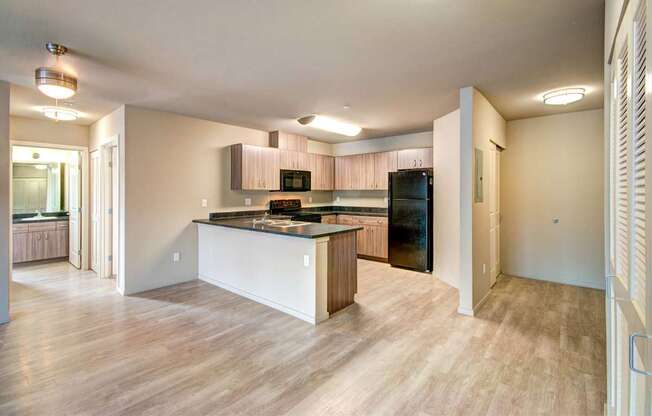A kitchen with a black fridge and a wooden island.