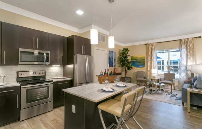 a kitchen with stainless steel appliances and a marble counter top at Aster Apartments, Beachwood, OH 44122