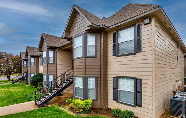 A beige house with a black staircase leading to the second floor.