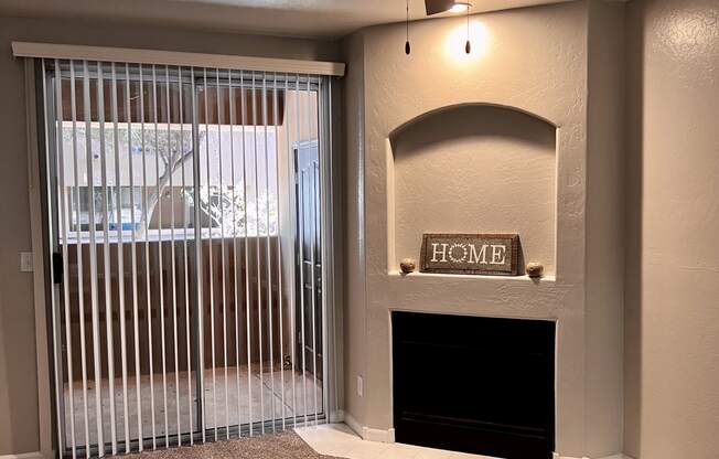 a living room with a fireplace and a ceiling fan