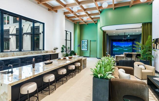 Spacious and stylish, the resident lounge at Modera Riverview features a modern demonstration kitchen, ample seating, and access to the golf simulator area.