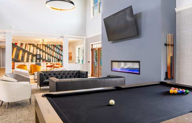 a living room with a pool table and a television