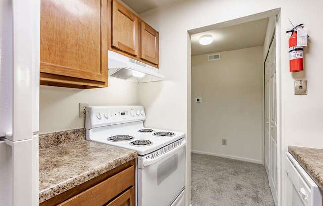 A kitchen with a white stove and wooden cabinets