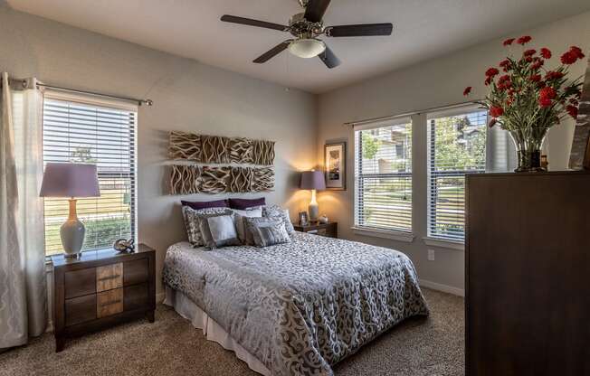 a bedroom with a large bed and a ceiling fan