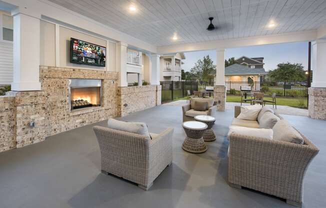 Poolside lounge with fireplace, TV and oversized chairs at at the Station at Savannah Quarters in Pooler, GA