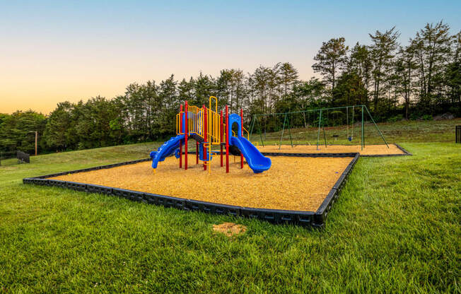 a playground with a swing set on a trampoline