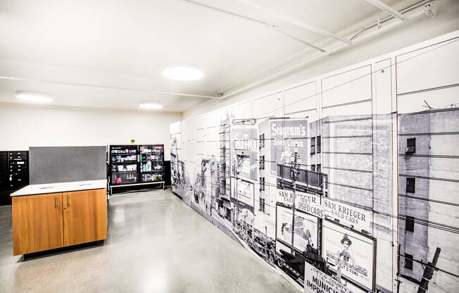 A black and white photo of a wall with a mural of a building and a wooden counter in the foreground.