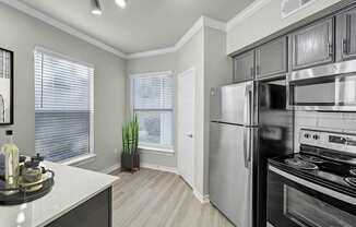 A kitchen with a stove top oven and a refrigerator.