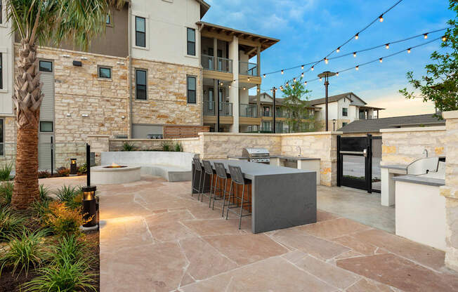 a patio with a bar and a building with lights
