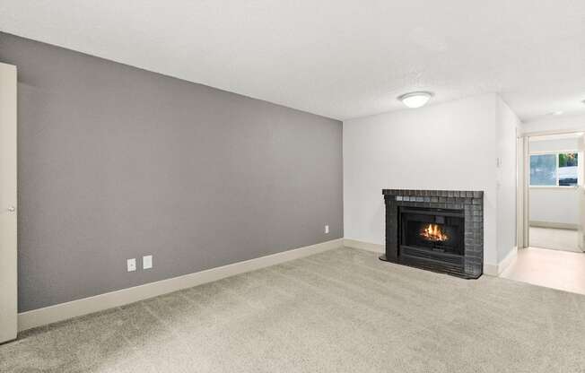 A living room with a fireplace and carpeted floor.