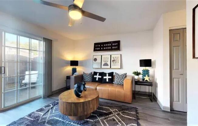 A living room with a brown leather sofa and a wooden coffee table.
