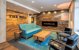 A blue sofa sits in front of a stone wall with a fireplace