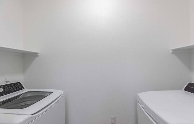 A white washing machine and dryer in a small laundry room.