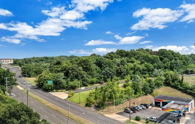 an aerial view of a parking lot with a highway and trees