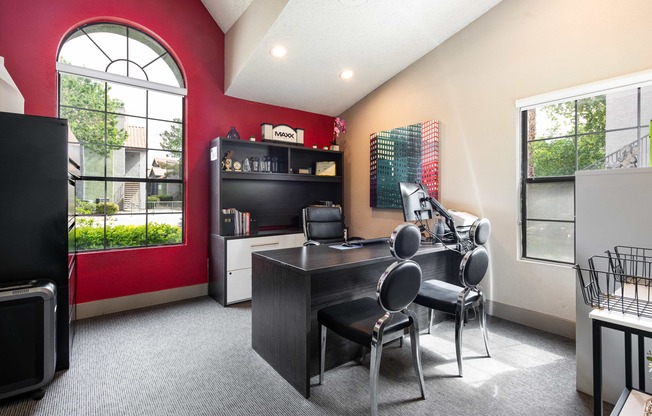 a home office with a desk and chairs and a large window