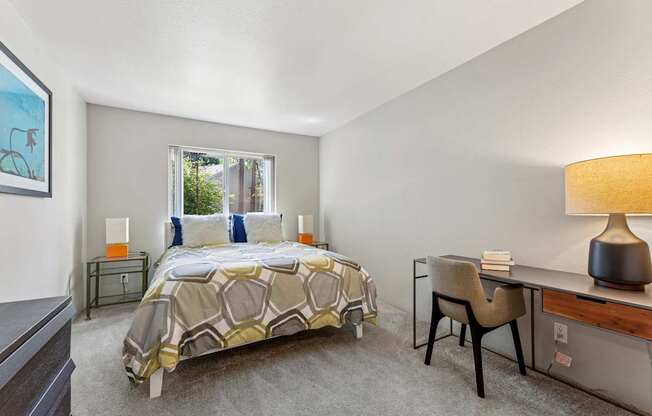 A bedroom with a bed, desk, and chair.