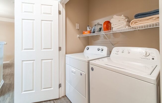a white washer and dryer in a laundry room with a closet